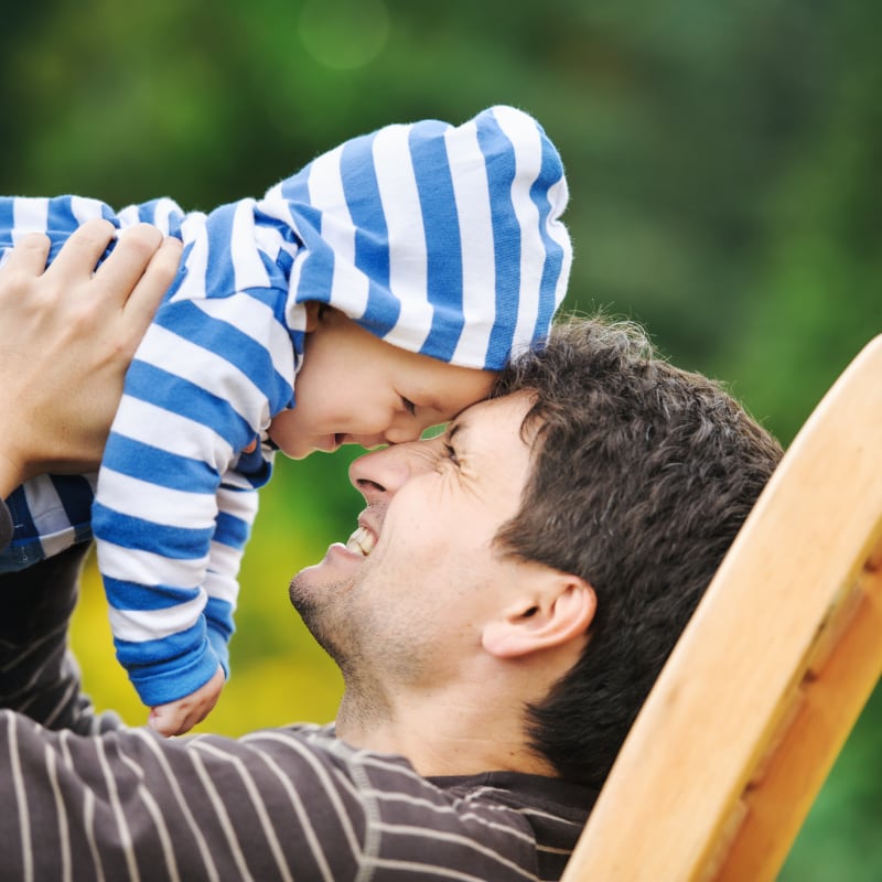 New Patients Smiling father holds his toddler