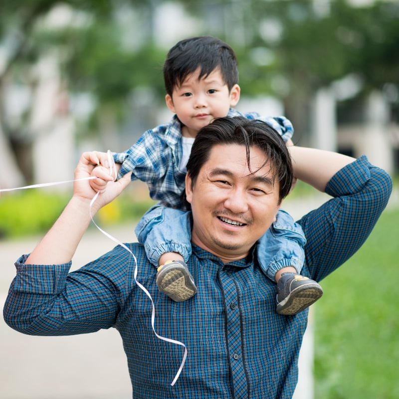 A Chinese father carries his young son on his shoulders